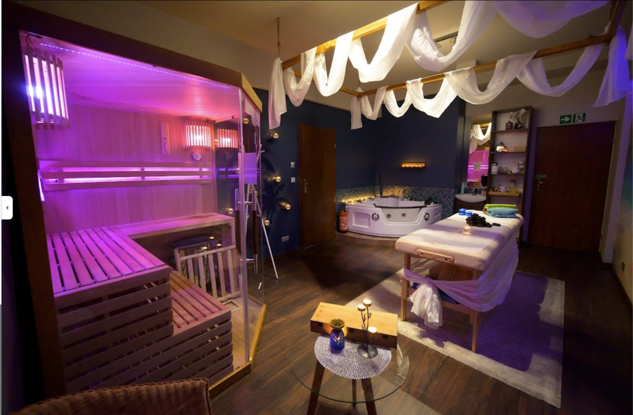 Wnętrze gabinetu spa z jacuzzi, sauną oraz miejscem do masażu.